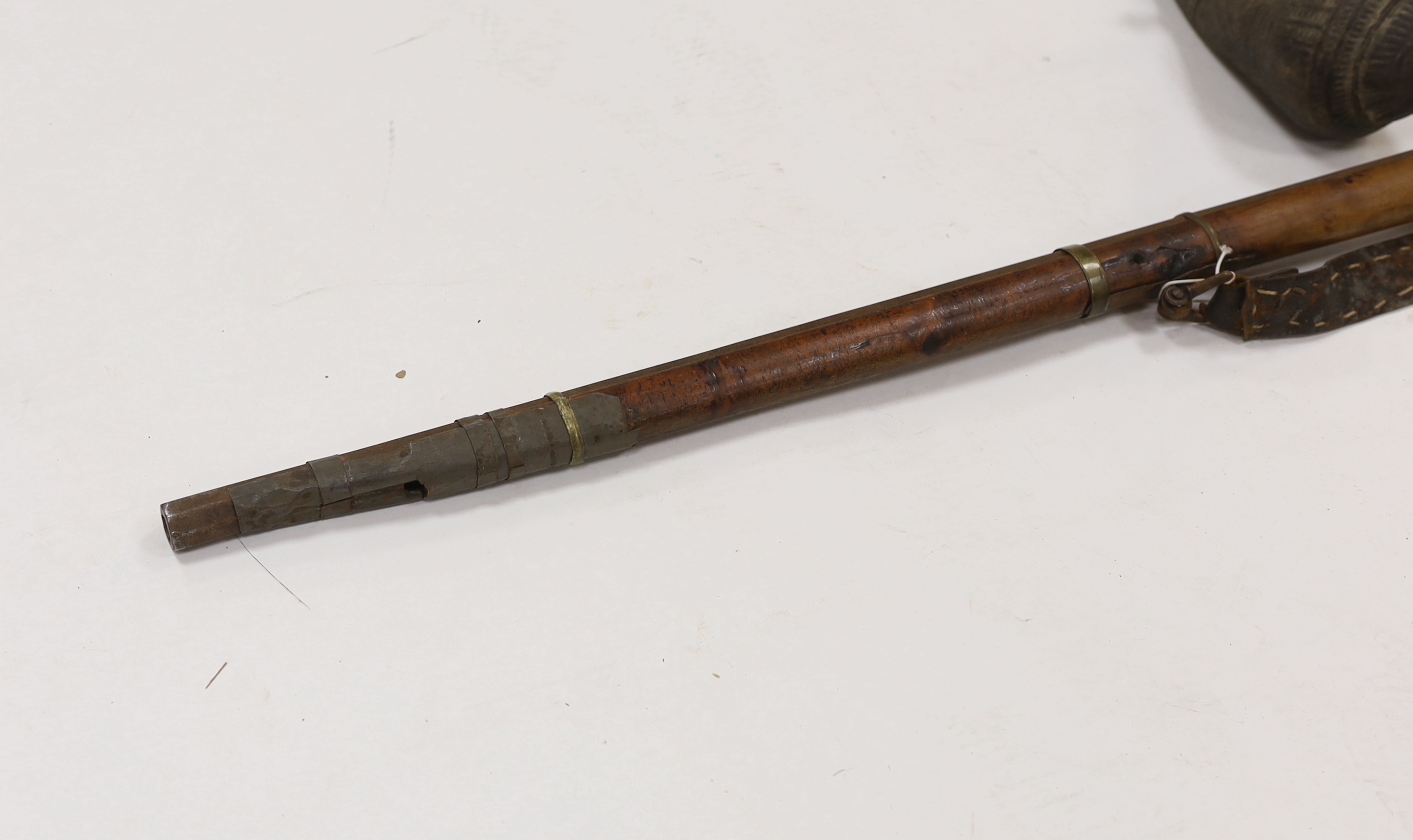 An Afghan percussion rifle with octagonal barrel and brass mounts, barrel 105.5cm, together with two leather powder flasks